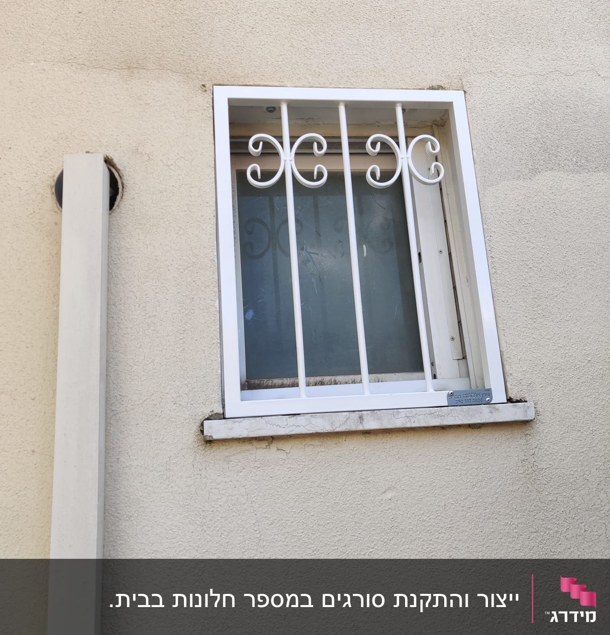 חלון עם סורגים לבנים על קיר חיצוני